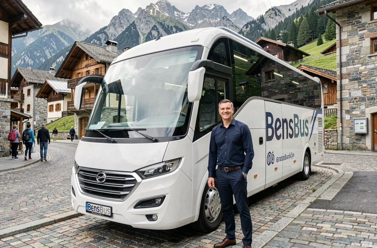 Chauffeur de BensBus en chemise bleue devant un minibus blanc dans un village alpin de l'Isère